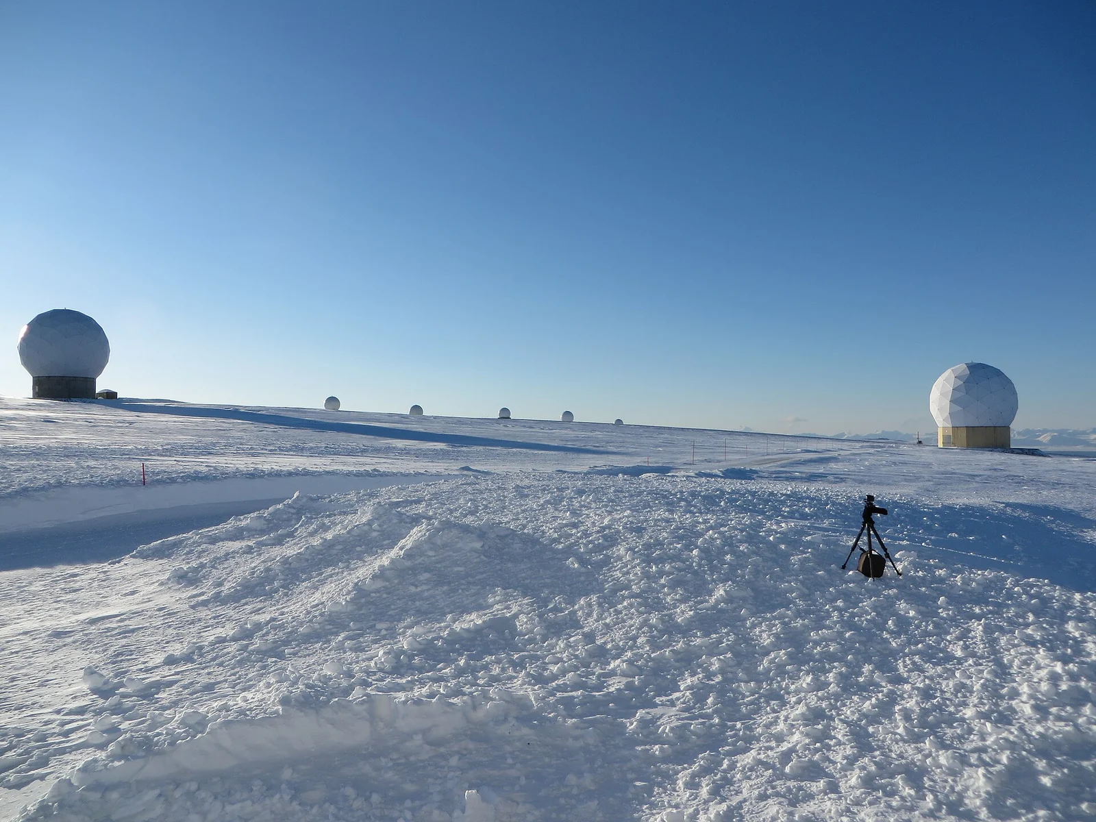 White antenna domes on the snow-covered plateau at Svalbard Satellite Station.