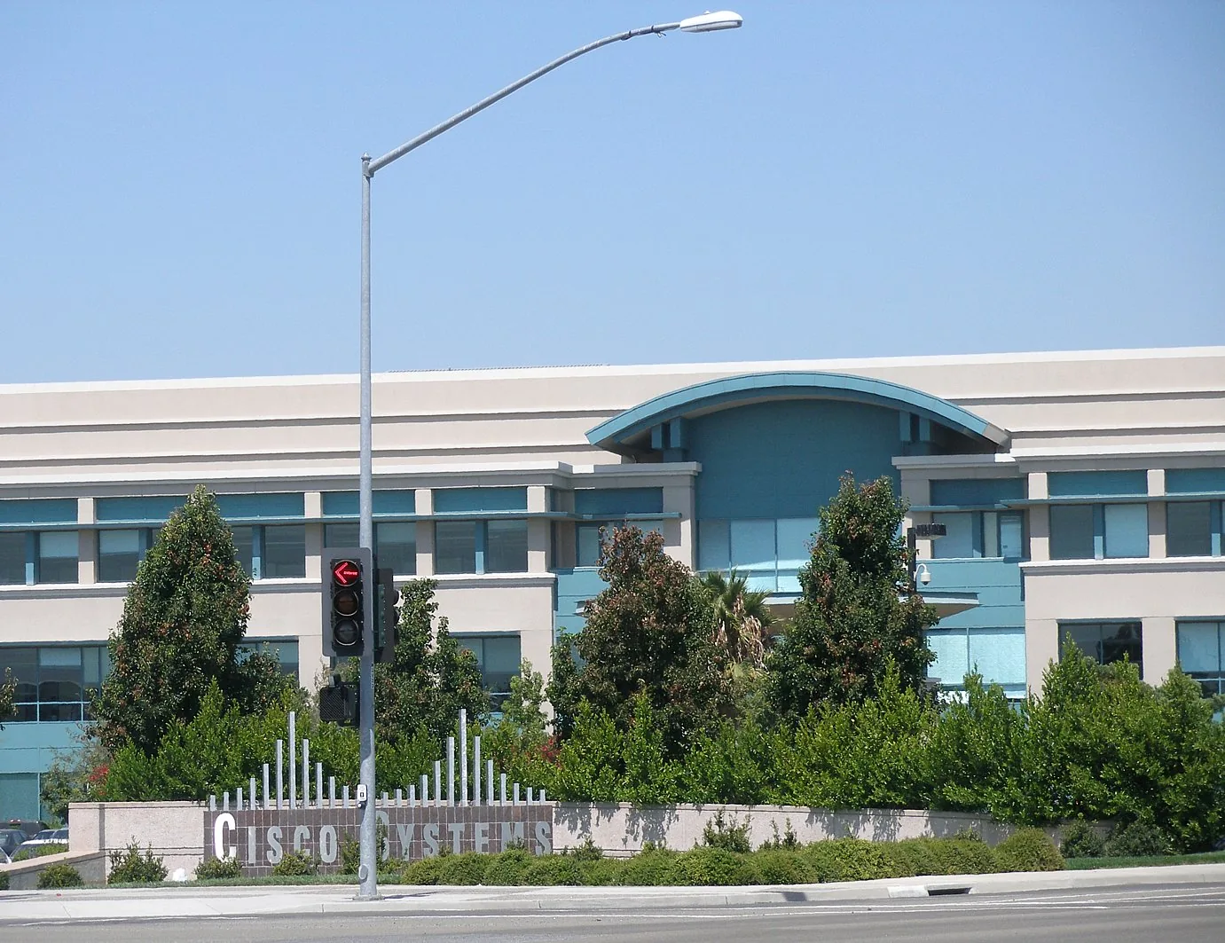Cisco Building 2 in San Jose, with a Cisco Systems sign and trees in front.