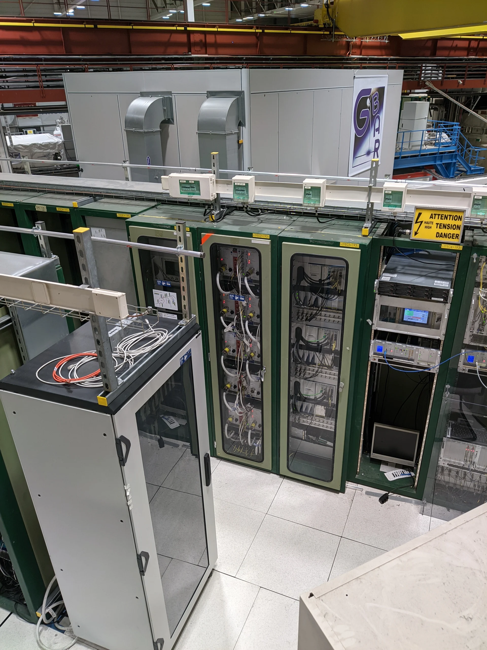 Server racks and cables beside the GBAR experiment at CERN.