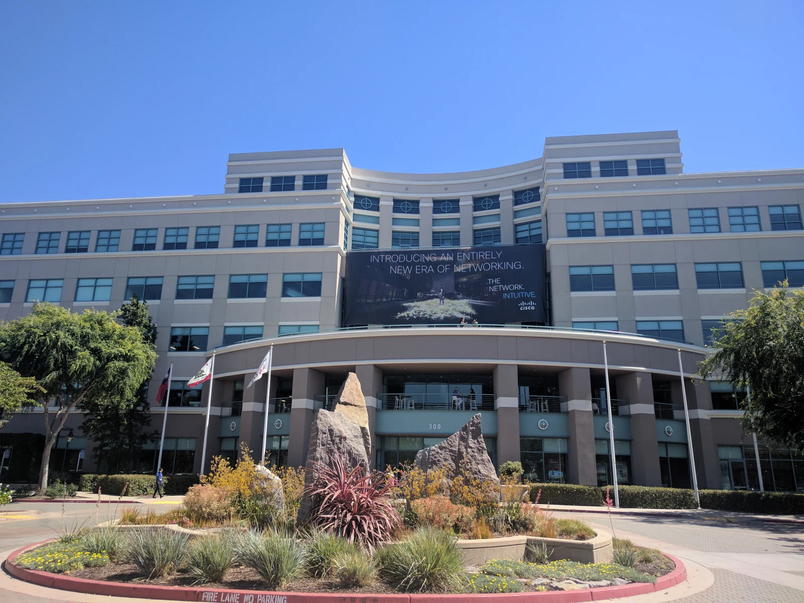 A Cisco office building with a curved facade and landscaping in San Jose.