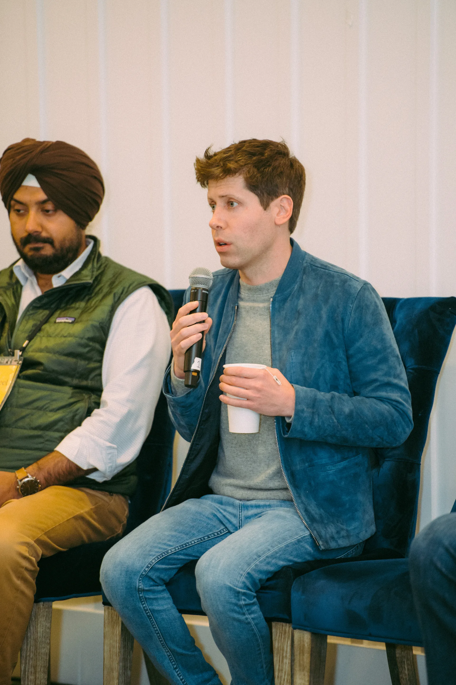 Sam Altman seated with a microphone at Village Global’s Grove event in 2022.