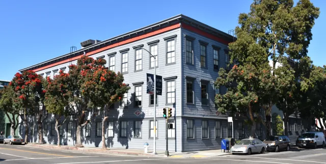 The Pioneer Building’s gray facade and flowering trees in San Francisco.