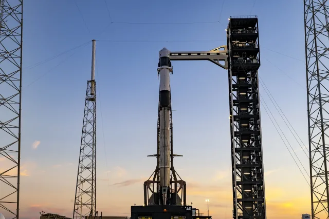 A SpaceX Falcon 9 rocket and Dragon spacecraft beside the access tower at Cape Canaveral, photographed September 27, 2026.