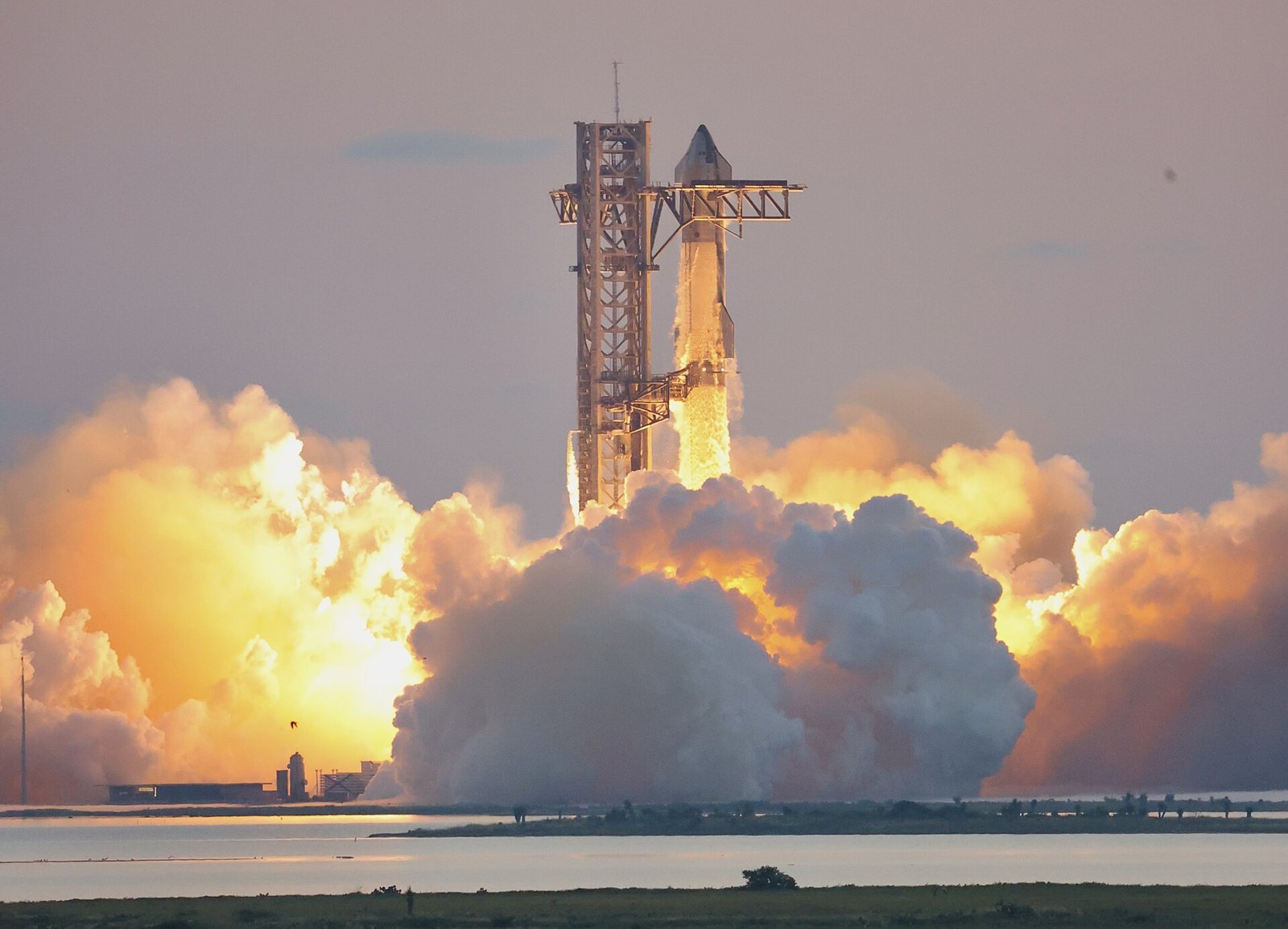 Flames and exhaust surround a SpaceX Starship rocket at ignition