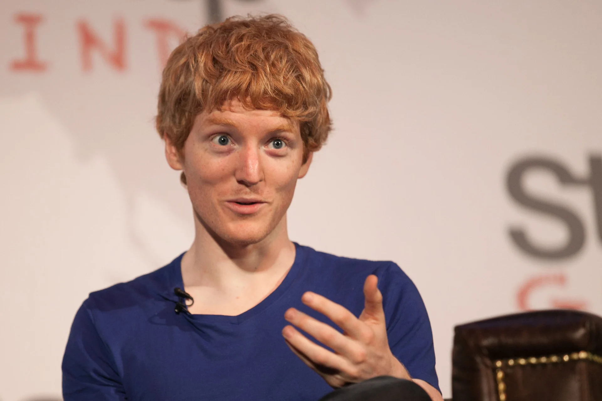 Stripe co-founder Patrick Collison speaking while seated in a blue shirt.