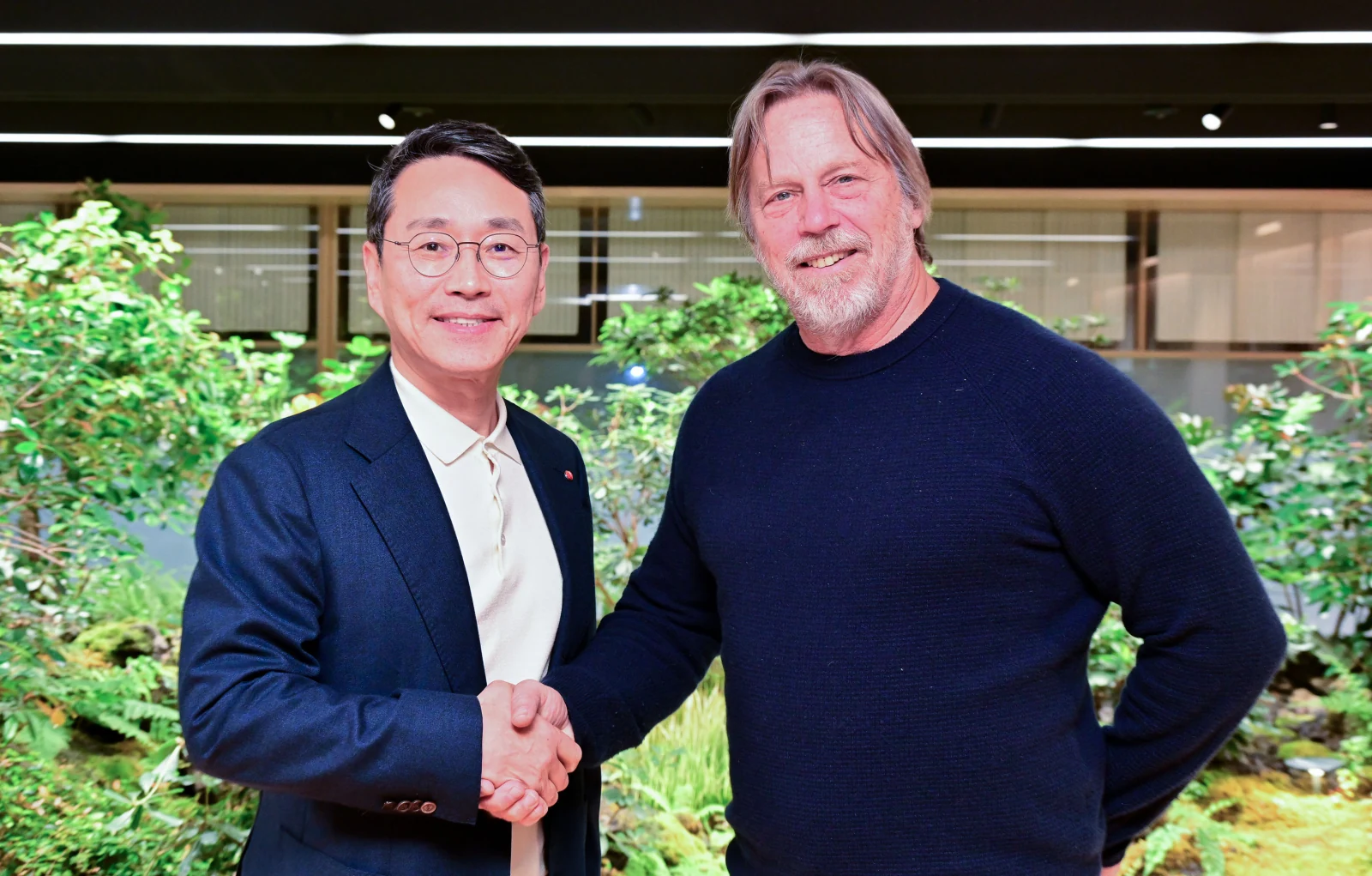 Jim Keller and Cho Joo-wan shake hands at an LG office.