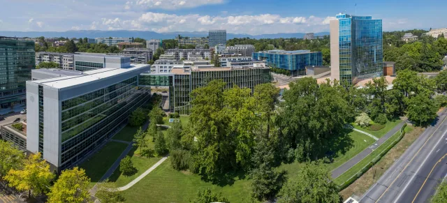 WIPO headquarters in Geneva, with glass office buildings, a conference hall and landscaped grounds.