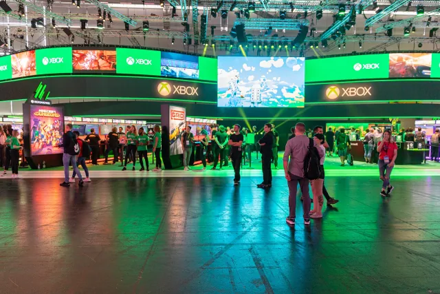 Visitors stand in front of the green Xbox exhibition stand at Gamescom in Cologne.