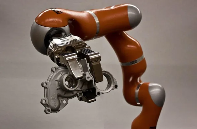 A three-finger robotic hand attached to an articulated arm in NIST’s manipulation testbed.